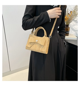 Détail d'un sac à bandoulière kaki avec un grand nœud et une boucle cœur en strass