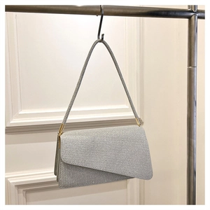 Détail du sac à paillettes argentées avec rabat asymétrique et boucles métalliques