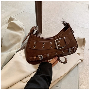 Detail of dark brown leather hobo bag with silver buckle straps and metal eyelets