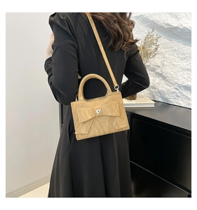 Détail du sac à main kaki clair avec nœud, cristal de cœur et cuir plissé chic