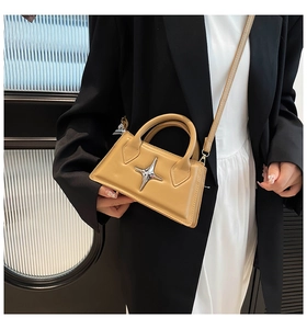 Détail du sac bandoulière marron clair avec étoile argentée et cuir mat texturé