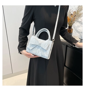 Détail du sac bleu clair avec nœud, strass en cœur et texture effet marbré chic
