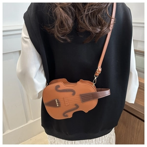 Detailed view of violin-shaped crossbody bag featuring faux F-holes and golden hardware
