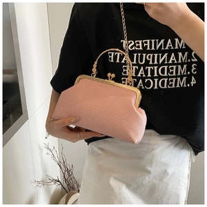 Detailed close-up of pink woven evening bag with gold metal handle and chain strap