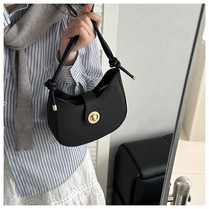 Detail of black crescent shoulder bag with gold twist lock and knot strap detail