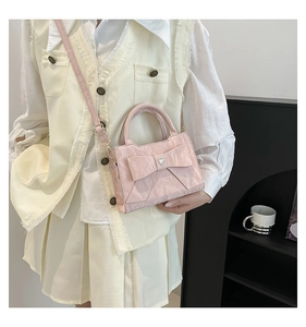 Gros plan du sac à main rose à nœud avec texture plissée et ornement en cristal cœur