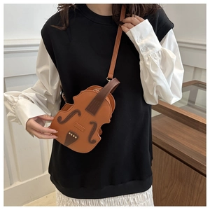 Crossbody bag in violin shape on model with brown leather patchwork and strap detail