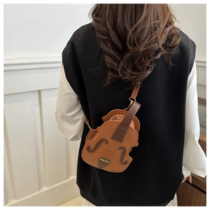 Detailed view of a brown violin-shaped crossbody bag worn by a model in a minimalist setting