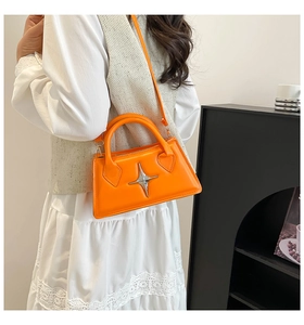 Gros plan du sac à main orange vif avec détail décoratif en métal en forme d'étoile