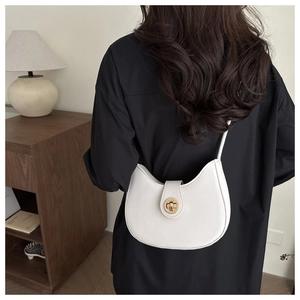 Chic white half-moon hobo bag with gold metal lock worn as a shoulder bag