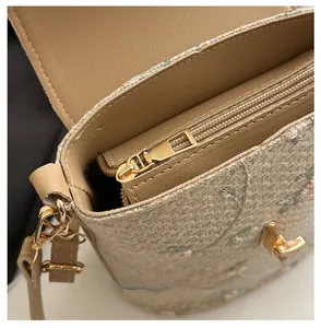 Detailed close-up of premium floral embroidery texture and smooth golden zipper closure