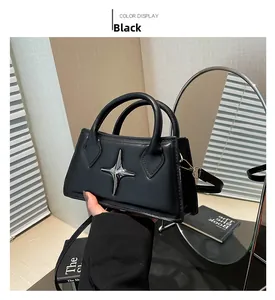Vue détaillée d'un mini sac carré noir avec accessoire étoile argentée et poignées