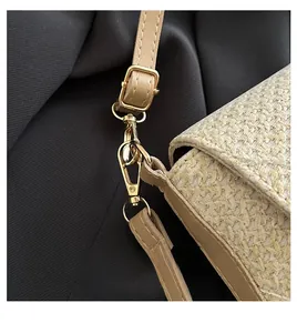 Detailed close-up of the golden metal hook and woven texture on a beige shoulder bag