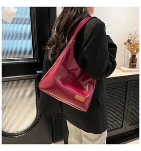 Polished burgundy faux leather hobo tote bag shown worn on shoulder in a home setting