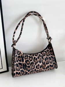Detail of trendy leopard print shoulder bag with black trim and elegant gold zipper hardware