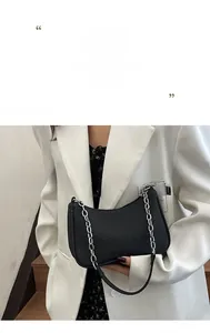 Detail of black crescent shoulder bag with silver chain strap and wave texture
