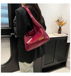 Detail of burgundy PU leather hobo tote bag featuring a minimalist strap and vintage brown label