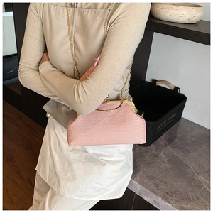 Detail of pink woven texture crossbody bag with gold metal handle and chain strap