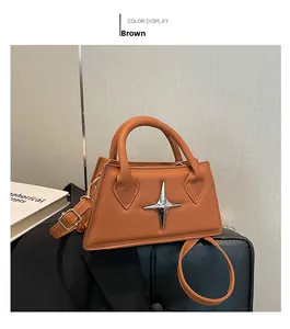 Détail du sac bandoulière en similicuir marron avec un ornement en métal étoile argentée