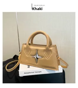 Détail du sac bandoulière en cuir kaki avec ornement étoile argentée et poignées hautes