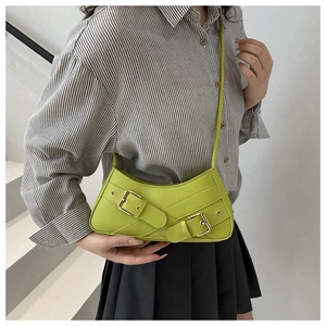 Detail of bright green underarm bag featuring decorative straps and metallic buckle accents