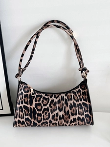 Detailed close-up of leopard print shoulder bag with gold zipper and dual straps