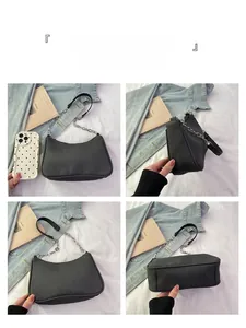 Detail view of black textured underarm bag with silver chain strap and leather handle
