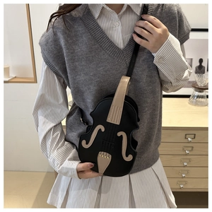 Detail of violin-shaped crossbody bag featuring classic F-hole design and leather texture