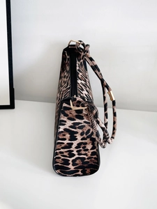 Detail of leopard print handbag showing golden hardware and textured faux leather finish