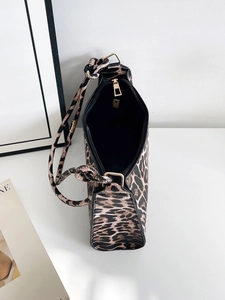 Detail of leopard print handbag showing the knotted shoulder strap and gold hardware