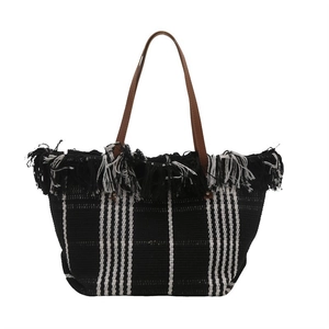 Handwoven tote bag with black and white vertical stripes and fringe edges for beach vacation