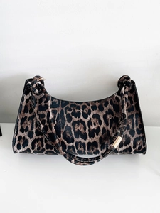Close-up of leopard print dumpling bag with shiny finish and gold metal hardware