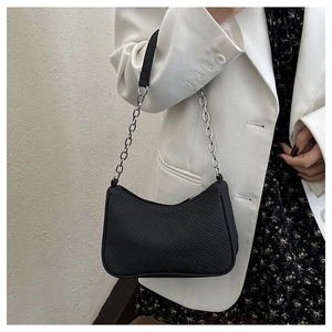 Detail of black hobo bag with diagonal texture and silver metal chain strap for women