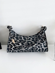 Close-up of leopard print shoulder bag with knotted strap and gold metal hardware detail