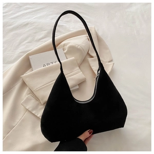 Détail du sac demi-lune minimaliste en daim noir avec fermeture éclair argentée élégante