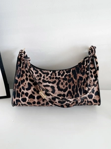 Close-up of leopard print handbag showing golden metal hardware and faux leather texture