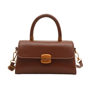 Vintage dark brown leather crossbody bag with top handle and gold hardware on white background
