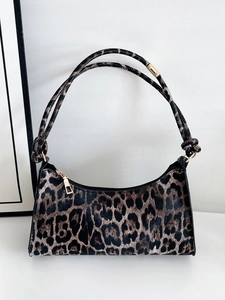 Detail of leopard print shoulder bag with gold zipper and knotted strap design