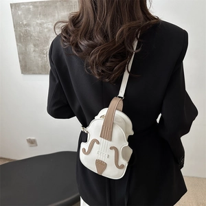 Creative white violin shaped leather crossbody bag with brown trim shown on a model