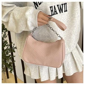 Pink twill hobo bag with silver chain strap shown in a trendy lifestyle outfit setting