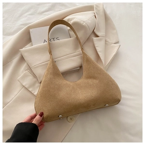 Détails du sac à bandoulière en daim avec pieds en métal argenté sur fond blanc doux