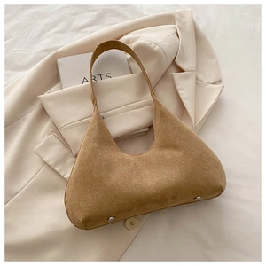 Vue détaillée du sac bandoulière en daim marron avec rivets argentés et design rétro