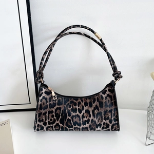 Close-up of leopard print hobo bag showing dual shoulder straps with decorative knots