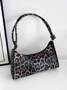 Detailed close-up of leopard print shoulder bag with golden zipper and textured fabric finish