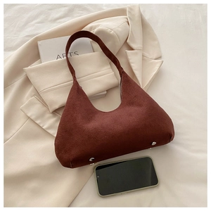 Vue détaillée du sac seau en daim marron foncé avec pieds de protection en métal