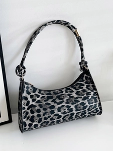Detail of grey leopard print baguette bag featuring knotted shoulder strap and zipper