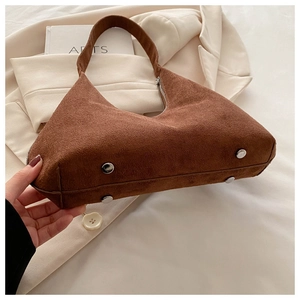 Vue détaillée du sac à main en daim marron avec clous de protection en métal