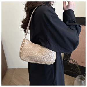 Detail of beige woven hobo bag showing texture and shoulder carry style on a model