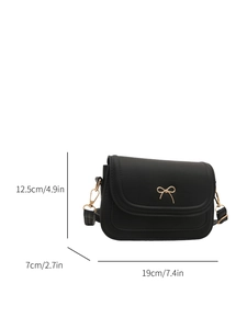 Detail view of a black shoulder bag with gold bow clasp and exact size measurements