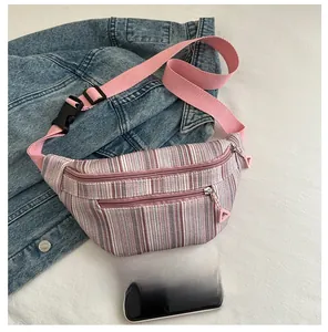 Détail d'un sac banane rayé avec sangle rose et un téléphone pour comparer la taille